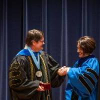 Provost Mili shaking hands with faculty member